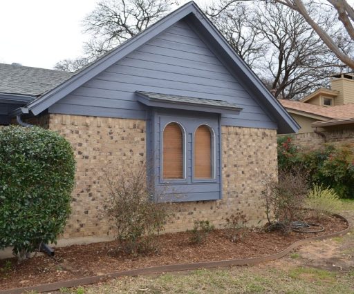 Exterior Carpentry and painting Arlington After Photo. Brick house with wood siding painted blue.